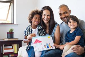 Family with child holding up drawing