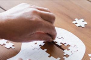 hand putting pieces into a puzzle-shaped head