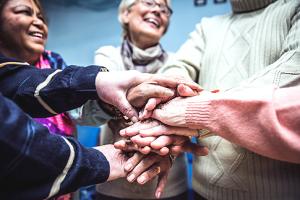 A group of individuals with hands stacked together