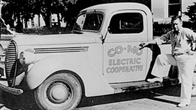 Early CoMo Electric Coop truck with driver
